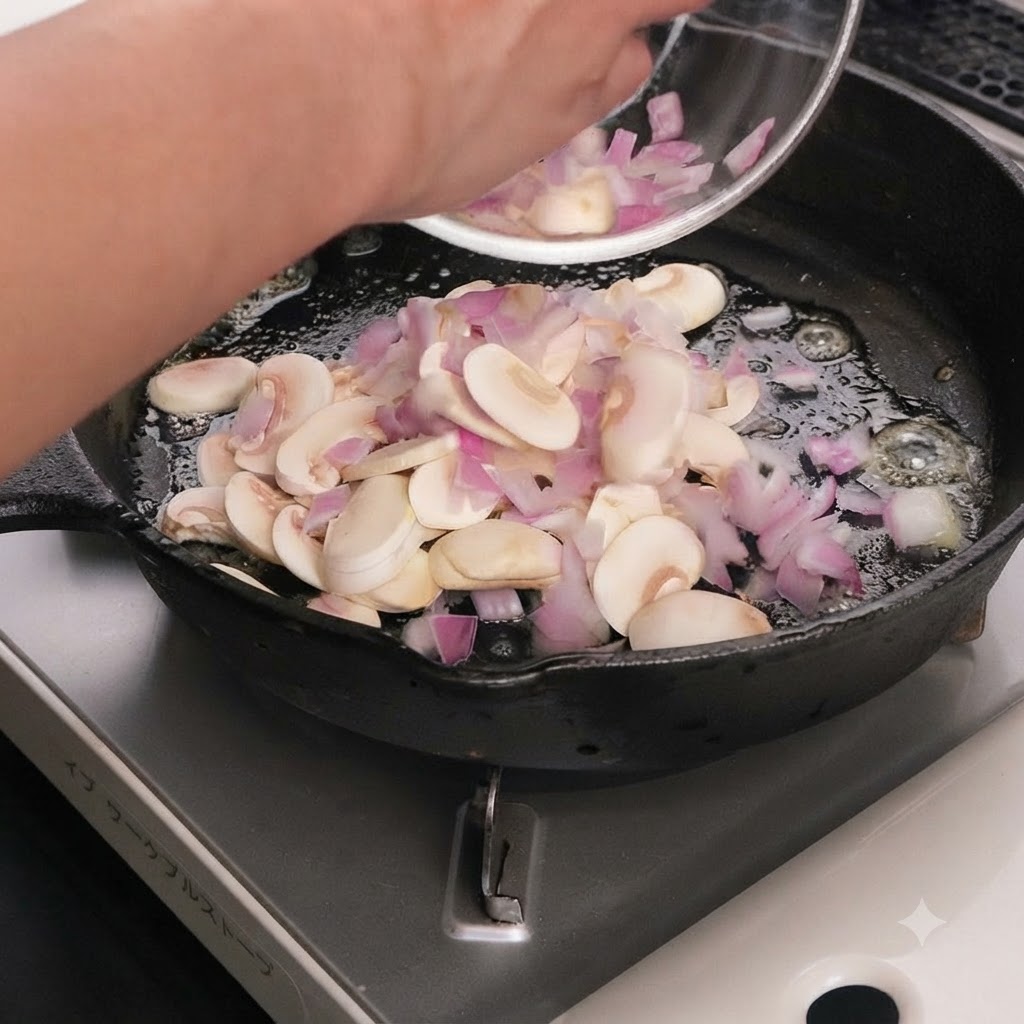 Geschnittene Pilze und rote Zwiebeln braten in geschmolzener Butter in einer Gusseisenpfanne.