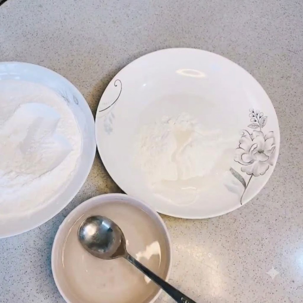 Klares Wasser wird in eine Schüssel mit trockenem Frittierpulver gegossen und mit einem Löffel umgerührt.