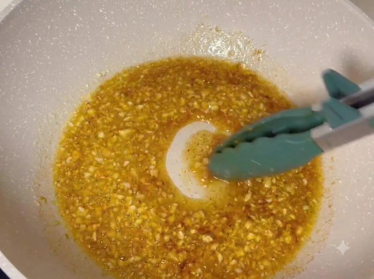 Frittierte Hähnchenschenkel werden in einer blubbernden Knoblauch-Butter-Glasur in einer Pfanne geschwenkt.
