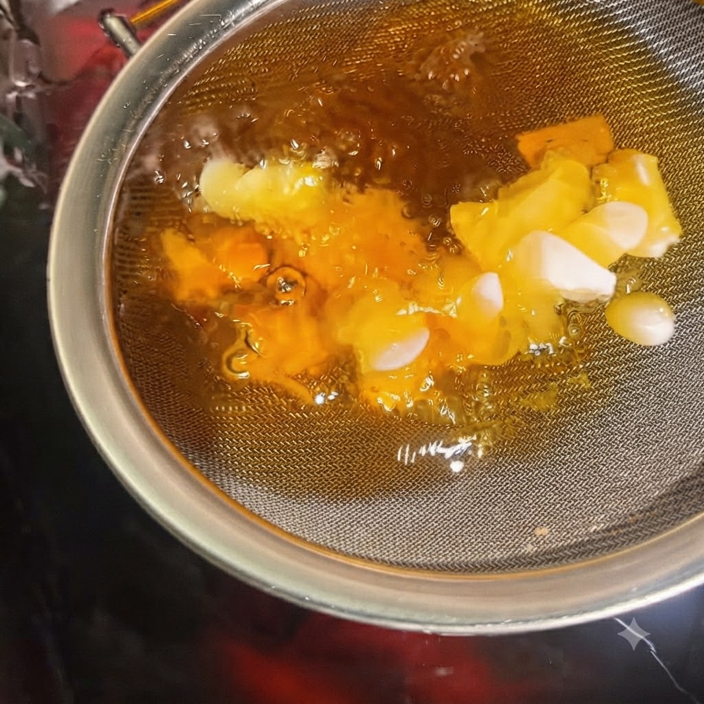 Knoblauchscheiben bräunen und werden in einem in heißes Öl getauchten Sieb knusprig.